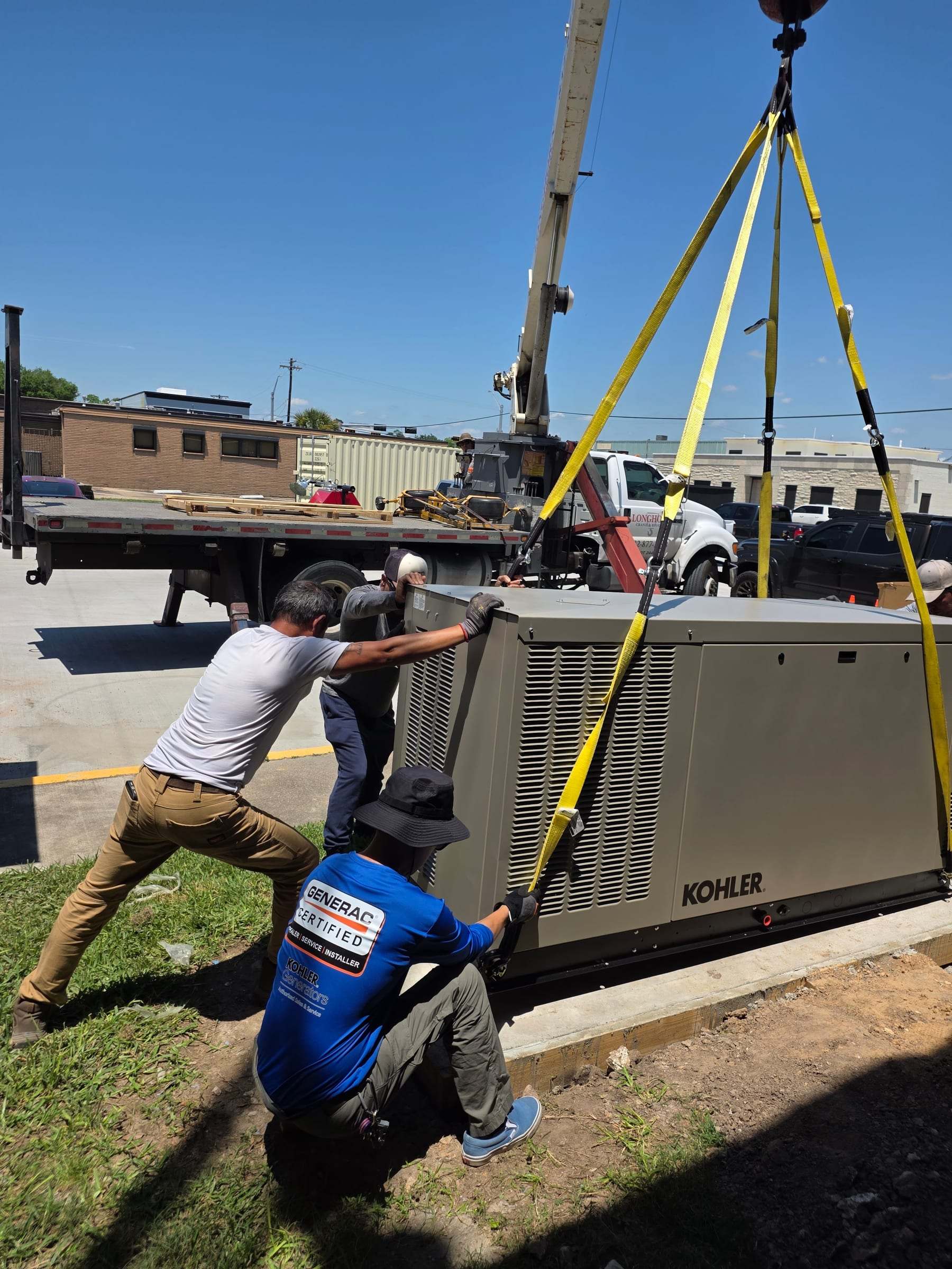 Critical Power Solutions crew positioning a liquid-cooled Kohler generator lifted from a flatbed by crane
